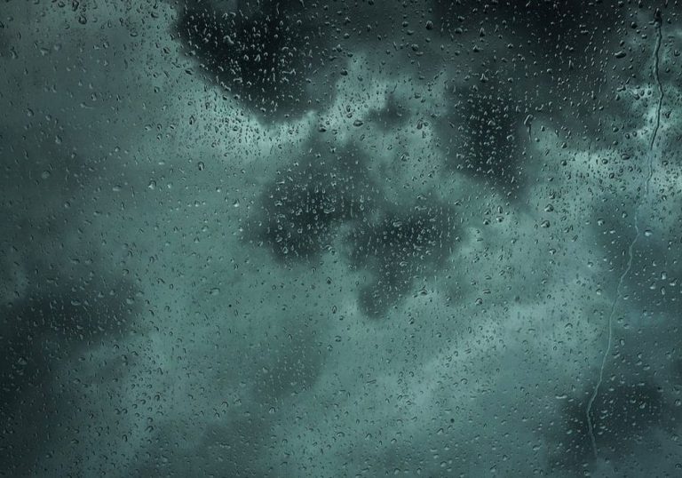 Rain on architectural glass during stormy weather.
