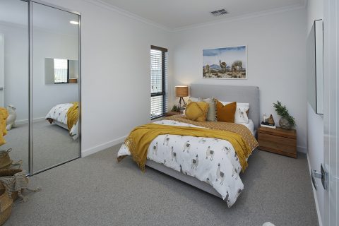 Bedroom with mirrored sliding wardrobe doors.