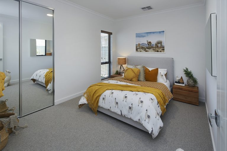 Bedroom with mirrored sliding wardrobe doors.