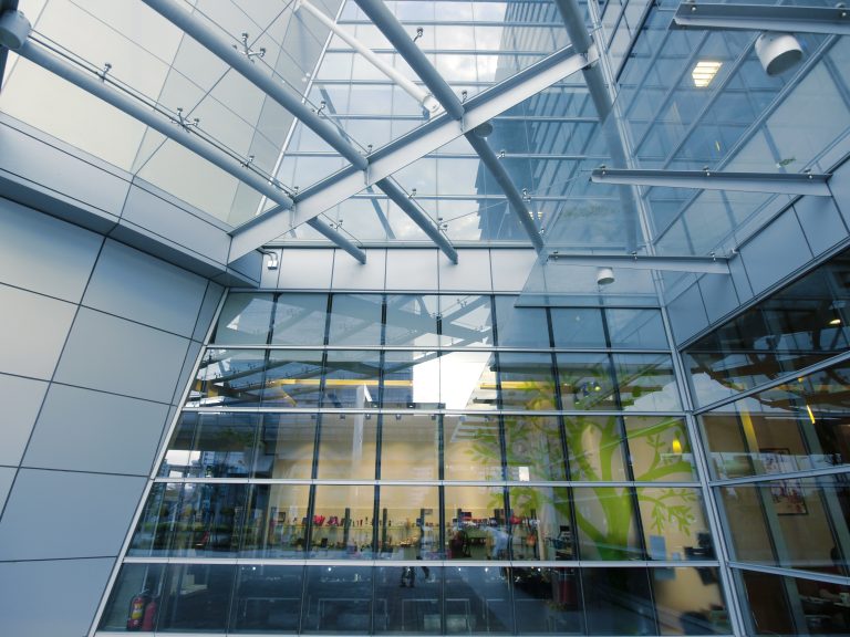 Commercial building featuring a structural glass façade and glazed canopy.