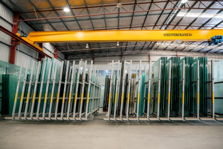Rows of finished glass panels stored on racks inside the Tough Glass facility.