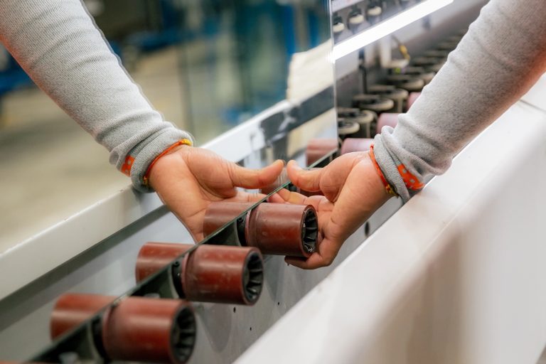 Close-up of a glass panel being guided across processing rollers.