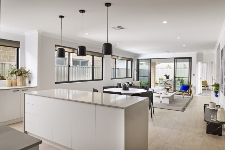 Open-plan kitchen and living area with large windows and sliding glass doors.