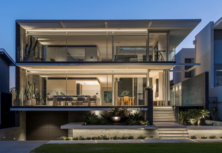 Contemporary home featuring expansive architectural glazing at dusk.