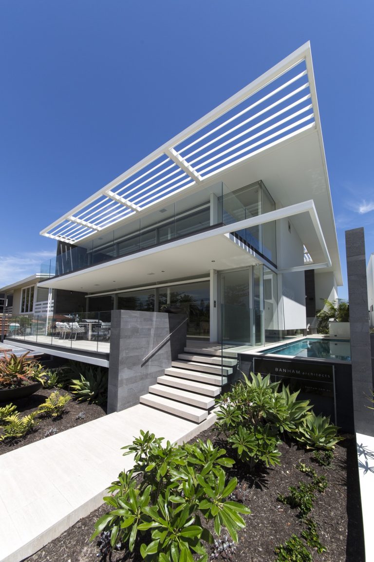 Contemporary home with glass balustrades, windows and pool fencing.