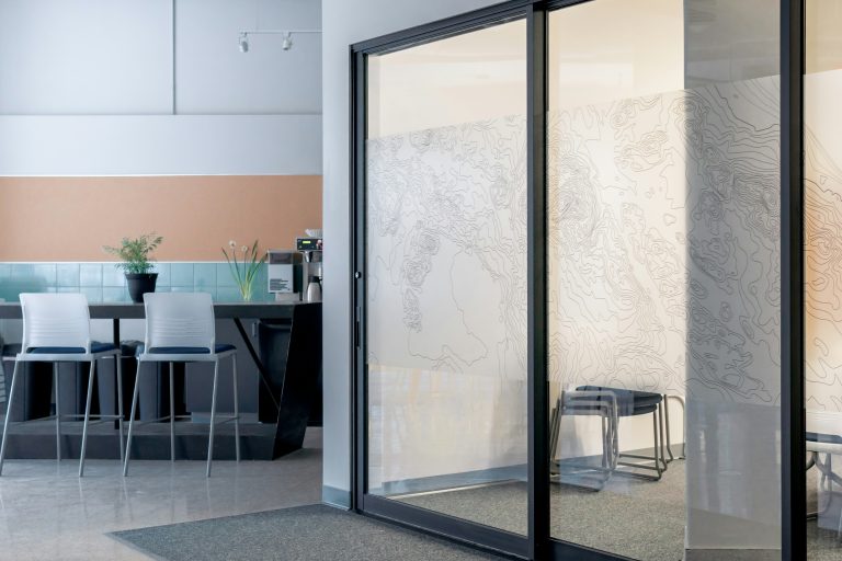 Glazed office partition providing partial visual privacy.