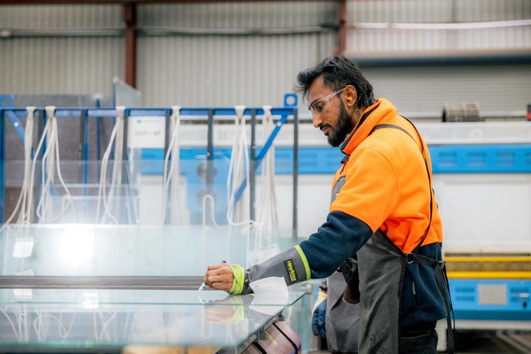 Tough Glass operator cleaning and preparing a glass panel for processing.