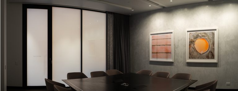 Boardroom separated by opaque switchable privacy glass.