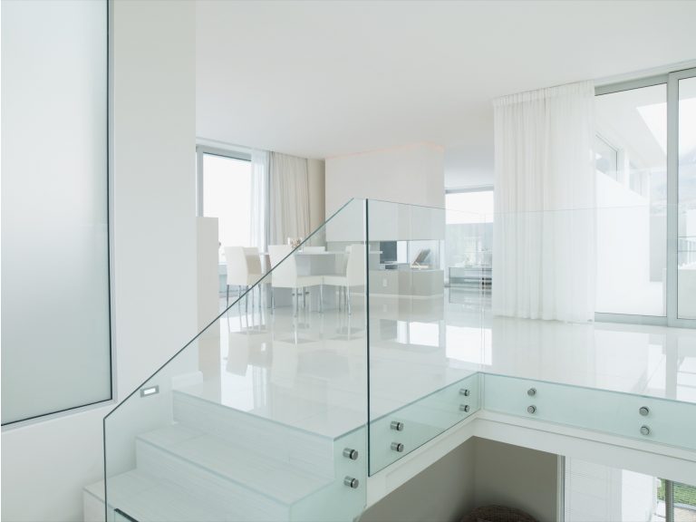 Clear glass balustrade beside a white staircase in a modern home
