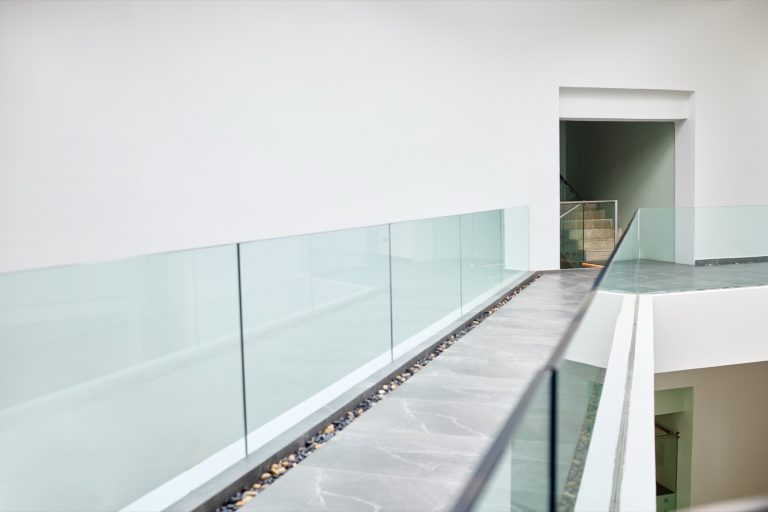 Toughened glass balustrade lining an interior walkway