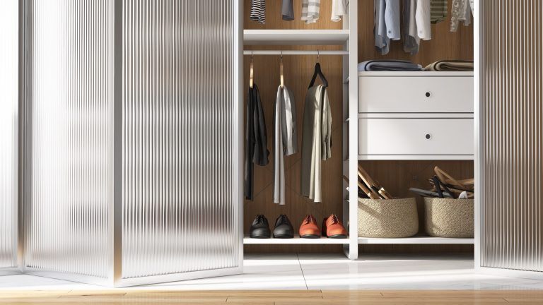 Low iron narrow reeded glass doors fronting a walk-in wardrobe