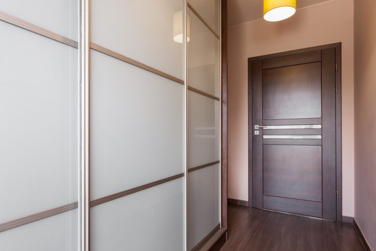 Super white glass wardrobe doors with slim frames in a hallway