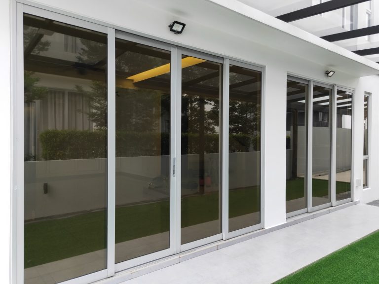 Grey tinted laminated glass sliding doors on a home exterior