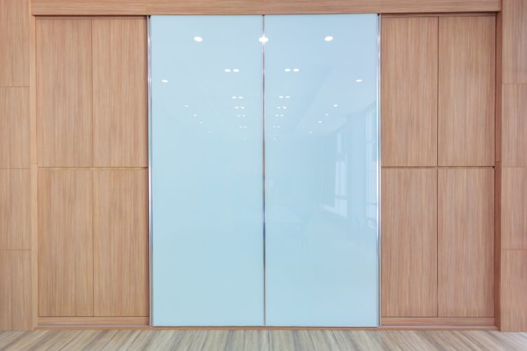 White vinyl backed glass sliding doors set into timber panelling